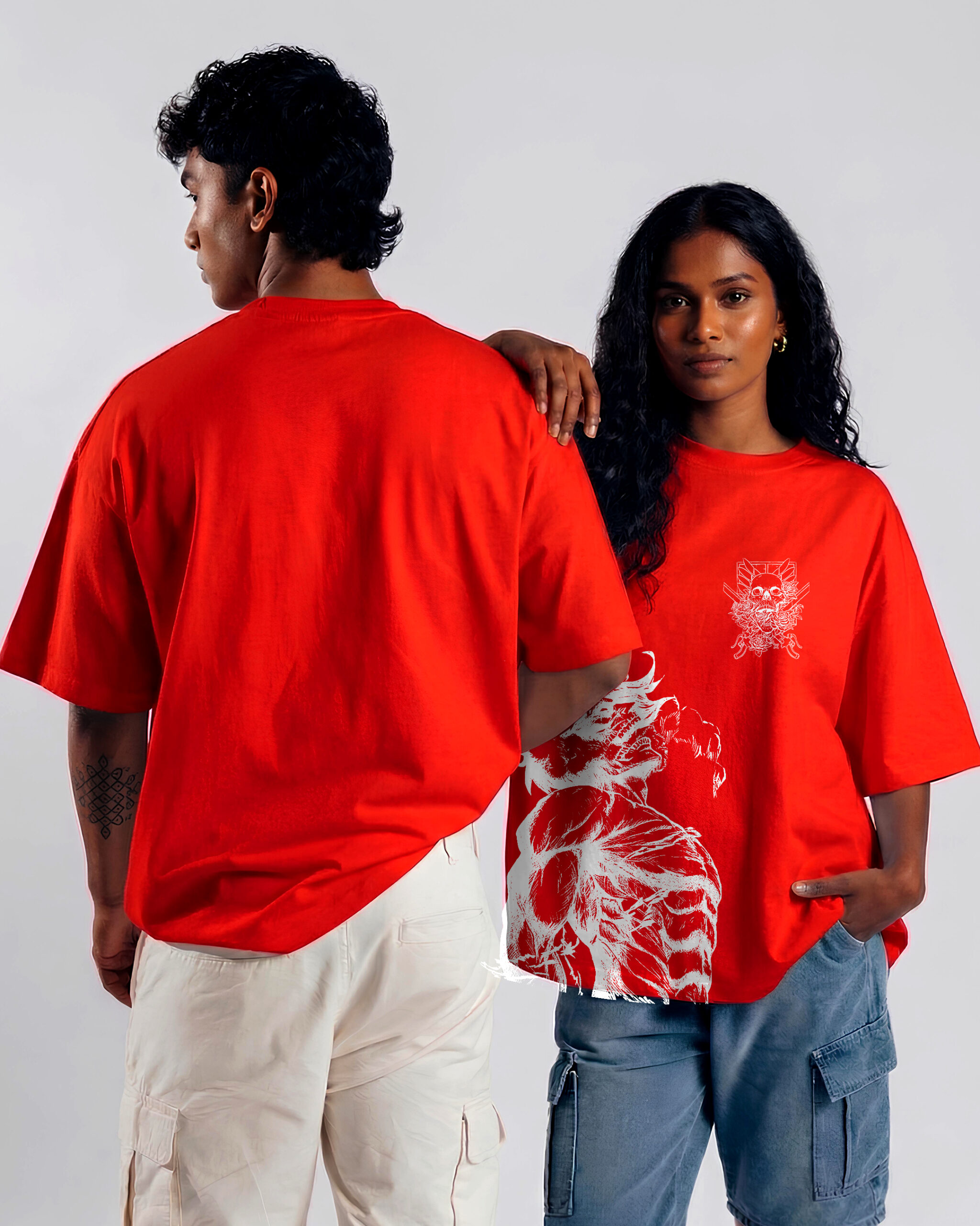 boy and girl wearing red attack on titan print t-shirt. boy is showing backside. Girl has her arm placed on the boy's shoulder.